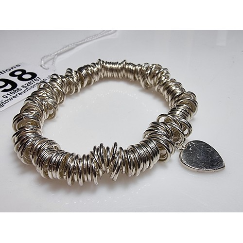 198 - A 925 silver expandable bracelet made up of many 925 silver rings, complete with a heart charm. In e... 