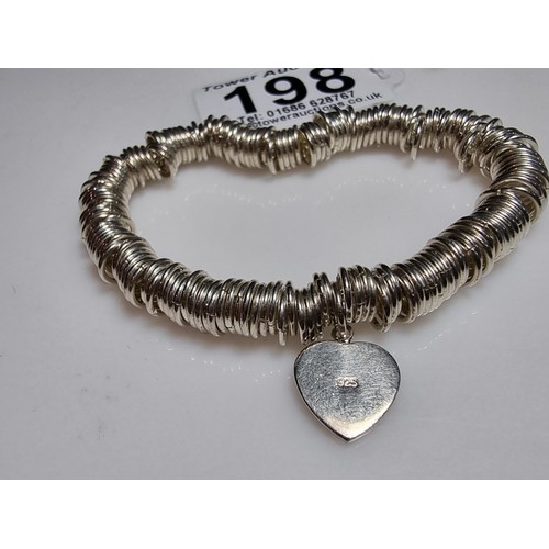 198 - A 925 silver expandable bracelet made up of many 925 silver rings, complete with a heart charm. In e... 