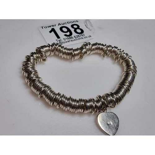 198 - A 925 silver expandable bracelet made up of many 925 silver rings, complete with a heart charm. In e... 