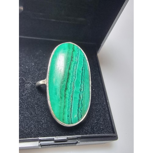 202 - A 925 silver dress ring inset with a large oblong malachite stone presenting a god natural grain. Ap... 