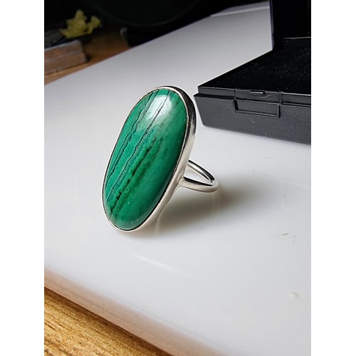 202 - A 925 silver dress ring inset with a large oblong malachite stone presenting a god natural grain. Ap... 