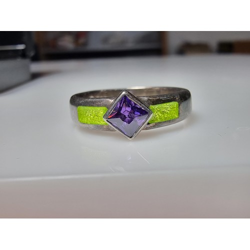 204 - A stunning 925 silver ring inset with a faceted purple glass stone and luminous green enamel insert.... 