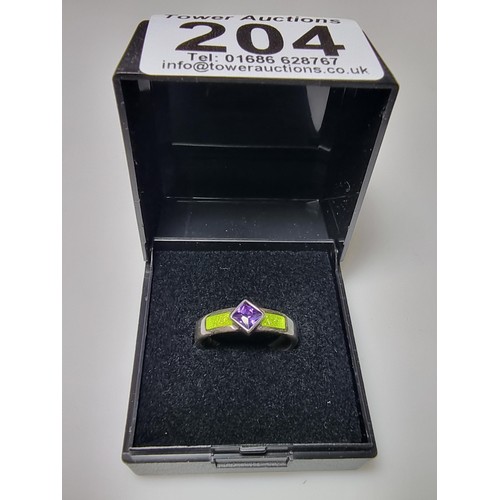 204 - A stunning 925 silver ring inset with a faceted purple glass stone and luminous green enamel insert.... 