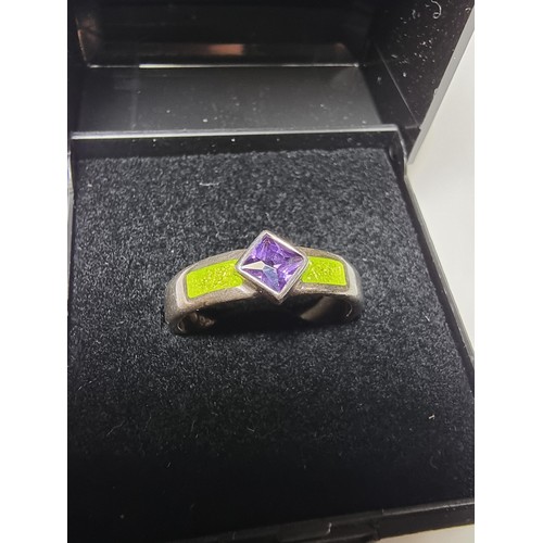 204 - A stunning 925 silver ring inset with a faceted purple glass stone and luminous green enamel insert.... 