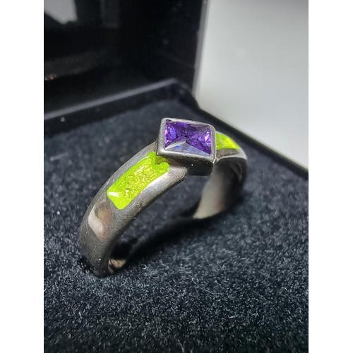 204 - A stunning 925 silver ring inset with a faceted purple glass stone and luminous green enamel insert.... 