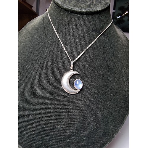 207 - A 925 silver moon pendant inset with a large oval moon stone, the moonstone presents excellent flash... 