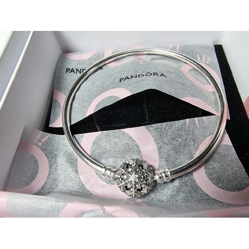 210 - A genuine Pandora 925 silver bangle with a snowflake charm inset with a crystal CZ stone, marked S92... 