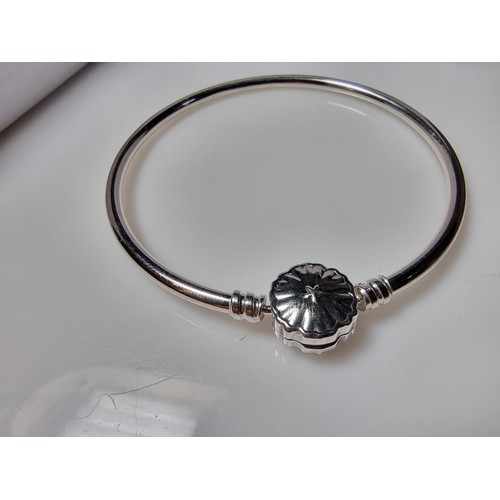 210 - A genuine Pandora 925 silver bangle with a snowflake charm inset with a crystal CZ stone, marked S92... 