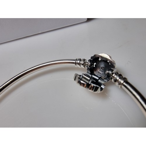 210 - A genuine Pandora 925 silver bangle with a snowflake charm inset with a crystal CZ stone, marked S92... 