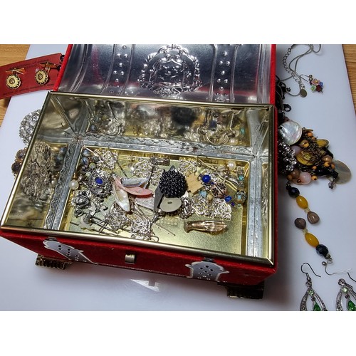 211 - An ornate toffee tin full of good fitted costume jewellery to include ornate earrings, brooches, nec... 