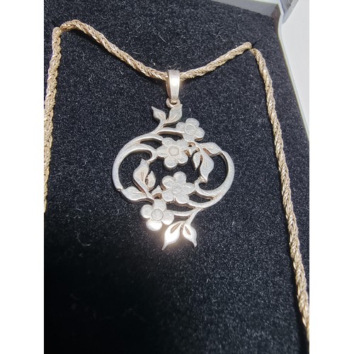 223 - A pretty 925 silver flower pendant sat on an 18