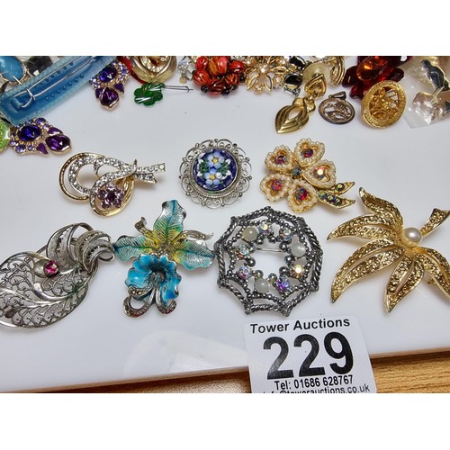 229 - A large collection of costume jewellery to include many various brooches (some with ornate designs) ... 