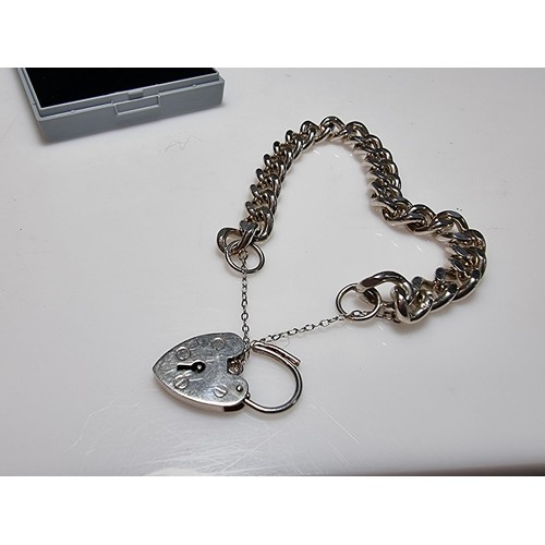 231 - A good quality heavy 1 troy oz hallmarked silver curb link bracelet with a large silver padlock char... 