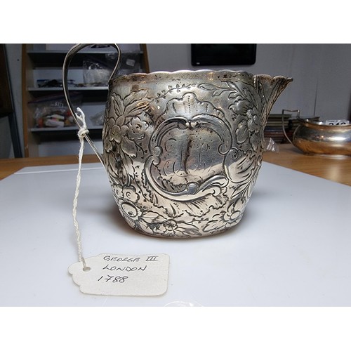 243 - A fine quality George III hallmarked silver milk jug with an ornate engraved and embossed design, ha... 