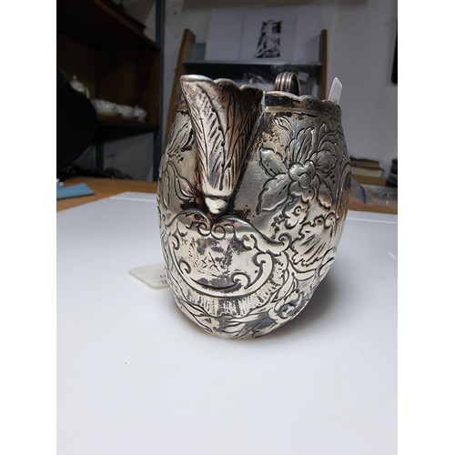 243 - A fine quality George III hallmarked silver milk jug with an ornate engraved and embossed design, ha... 