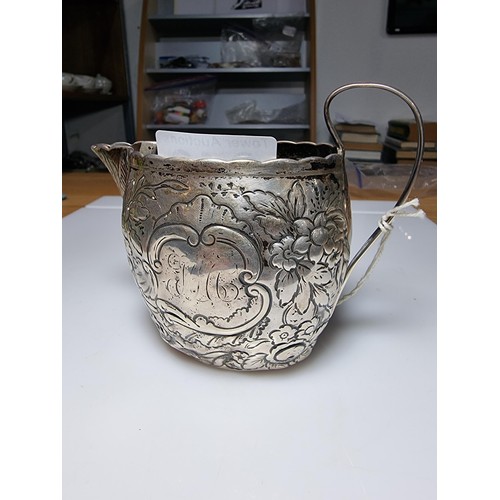 243 - A fine quality George III hallmarked silver milk jug with an ornate engraved and embossed design, ha... 