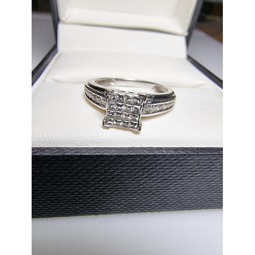 247 - A stunning hallmarked 9ct white gold and diamond engagement ring with 16 square diamonds to the cent... 