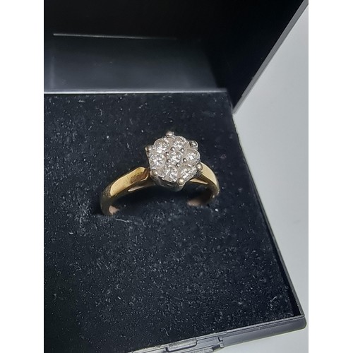 249 - A hallmarked 18ct yellow gold diamond cluster ring inset with 7 diamonds which are sparkly and livel... 