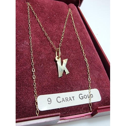 256 - A hallmarked 9ct gold neckless with the letter K pendant in good clean condition boxed, total weight... 