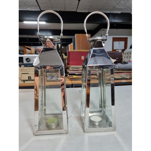 300 - 2x chrome tall tea light holders in the form of lanterns with carry handles both in good order stand... 