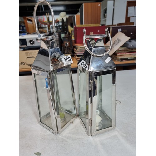 300 - 2x chrome tall tea light holders in the form of lanterns with carry handles both in good order stand... 