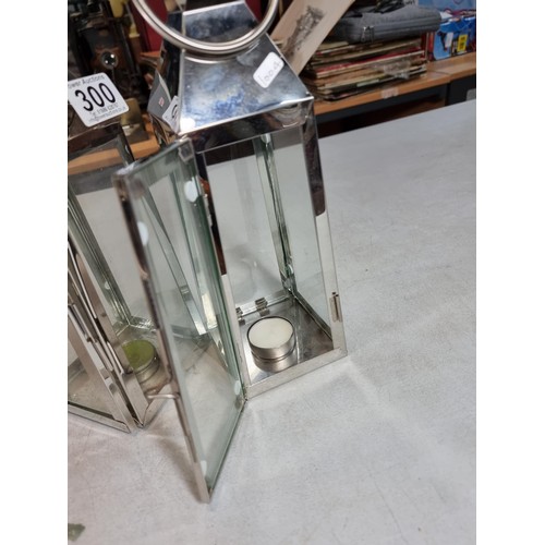 300 - 2x chrome tall tea light holders in the form of lanterns with carry handles both in good order stand... 