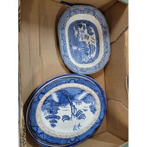 93 - 2x boxes containing a large quantity of blue and white design plates, bowls, chop plates inc Old Wil... 