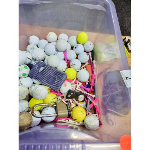 7 - A box full of golfing accessories to include a large quantity of golf balls of various makes, golf t... 