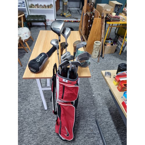 8 - A set of right handed golf clubs in a Nike bag to include 2 TaylorMade drivers, 2 vintage woods by A... 