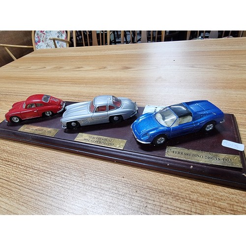 16 - A Dinky 3x model diecast sports car set all attached to a presentation plinth to include a Ferrari D... 