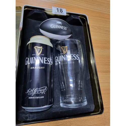 18 - A metal tin Guinness collectors set to include a draught beer pint glass along with a mini Rugby bal... 