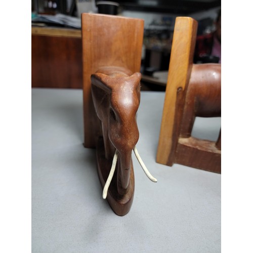 149 - Pair of hand carved elephant formed book ends in good order with metal and plastic tusks, each book ... 