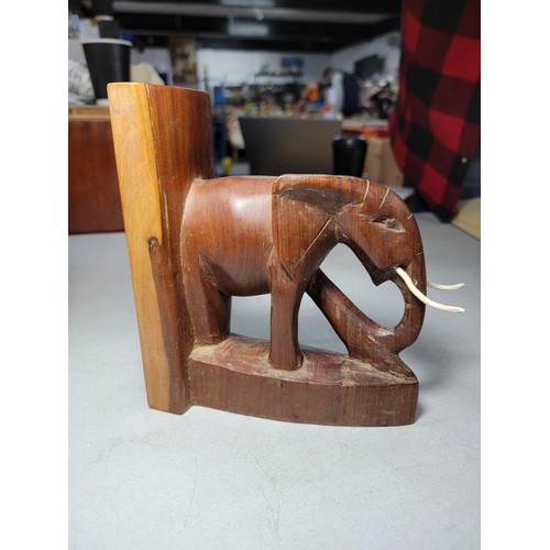 149 - Pair of hand carved elephant formed book ends in good order with metal and plastic tusks, each book ... 