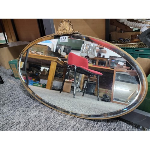 162 - Good quality bevel edged mirror with ornate shell crest to the top in good order height 45cm length ... 