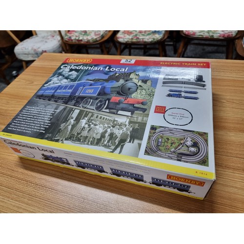 52 - A boxed Hornby R1016 Caledonian local train set, complete. Includes locomotive, 3 matching coaches a... 