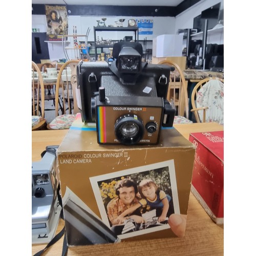 68 - A polaroid colour swinger II land camera, Polaroid The Button camera, a Ricoh FF.9 camera and a boxe... 