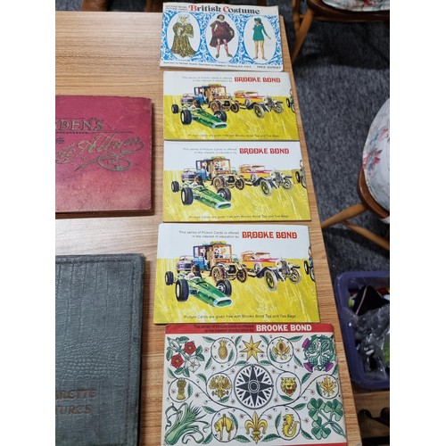 77 - A collection of cigarette card albums along with a quantity of  cigarette cards.