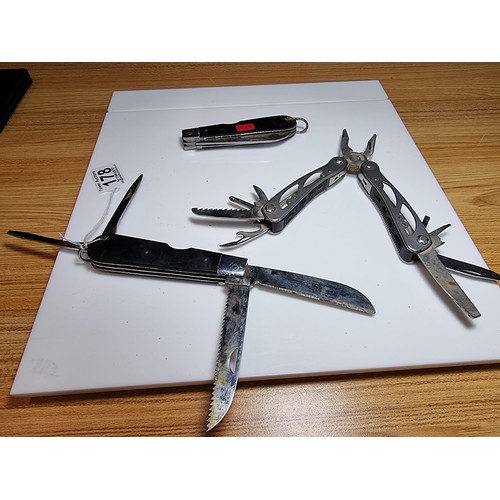 178 - 2 large folding knives along with a multi tool knife featuring pliers, saws, screwdrivers, etc. The ... 