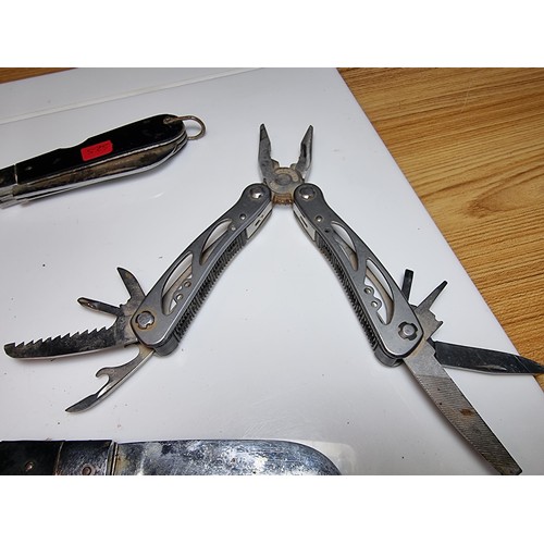 178 - 2 large folding knives along with a multi tool knife featuring pliers, saws, screwdrivers, etc. The ... 