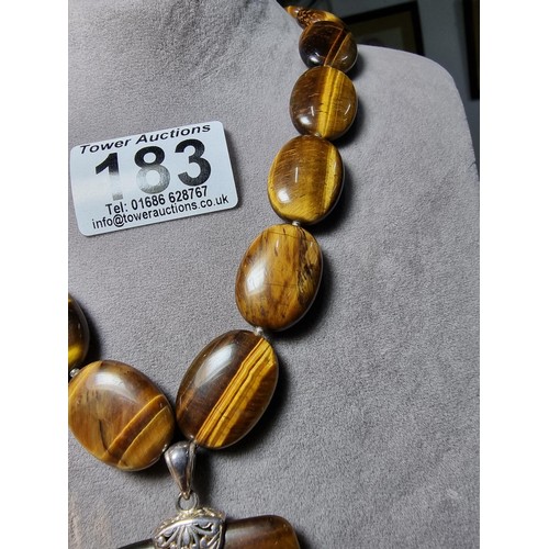 183 - A large impressive tigers eye beaded necklace with a large square tigers eye pendant presenting exce... 