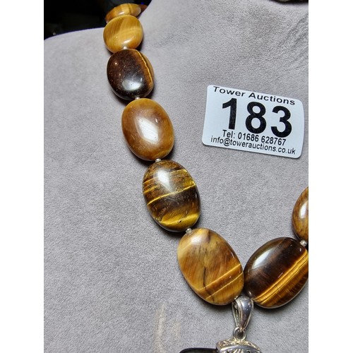 183 - A large impressive tigers eye beaded necklace with a large square tigers eye pendant presenting exce... 