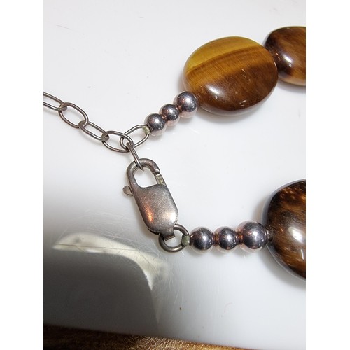 183 - A large impressive tigers eye beaded necklace with a large square tigers eye pendant presenting exce... 