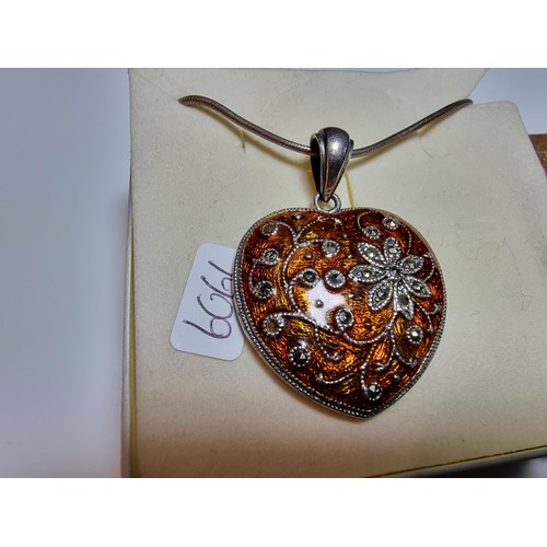 196 - A pretty 925 silver heart shaped pendant with an orange enamelled design inset with marcasite stones... 