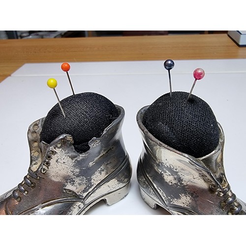 204 - 2 metal boot formed pin cushions in good condition, length of 9cm, height 6cm.