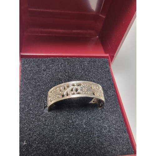 210 - A pretty 925 silver ring with a pierced floral design all the way around, having a faint silver mark... 