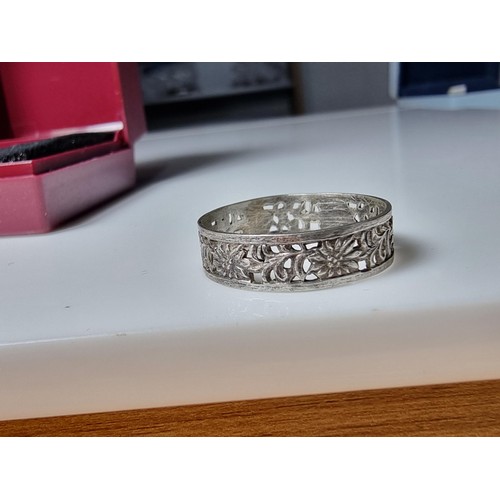 210 - A pretty 925 silver ring with a pierced floral design all the way around, having a faint silver mark... 