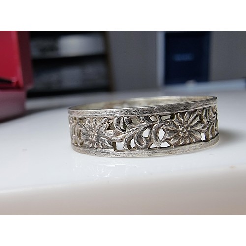 210 - A pretty 925 silver ring with a pierced floral design all the way around, having a faint silver mark... 