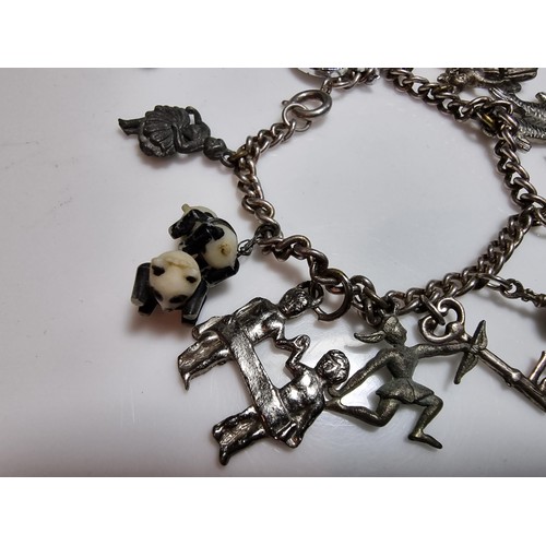 219 - A 925 silver charm bracelet containing 11 charms. A couple of the charms are silver however the rest... 