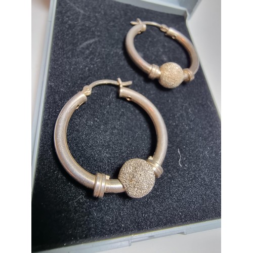 228 - A pair of 925 silver hoop earrings with a glittery ball design. In good clean condition, boxed. Diam... 