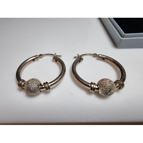 228 - A pair of 925 silver hoop earrings with a glittery ball design. In good clean condition, boxed. Diam... 